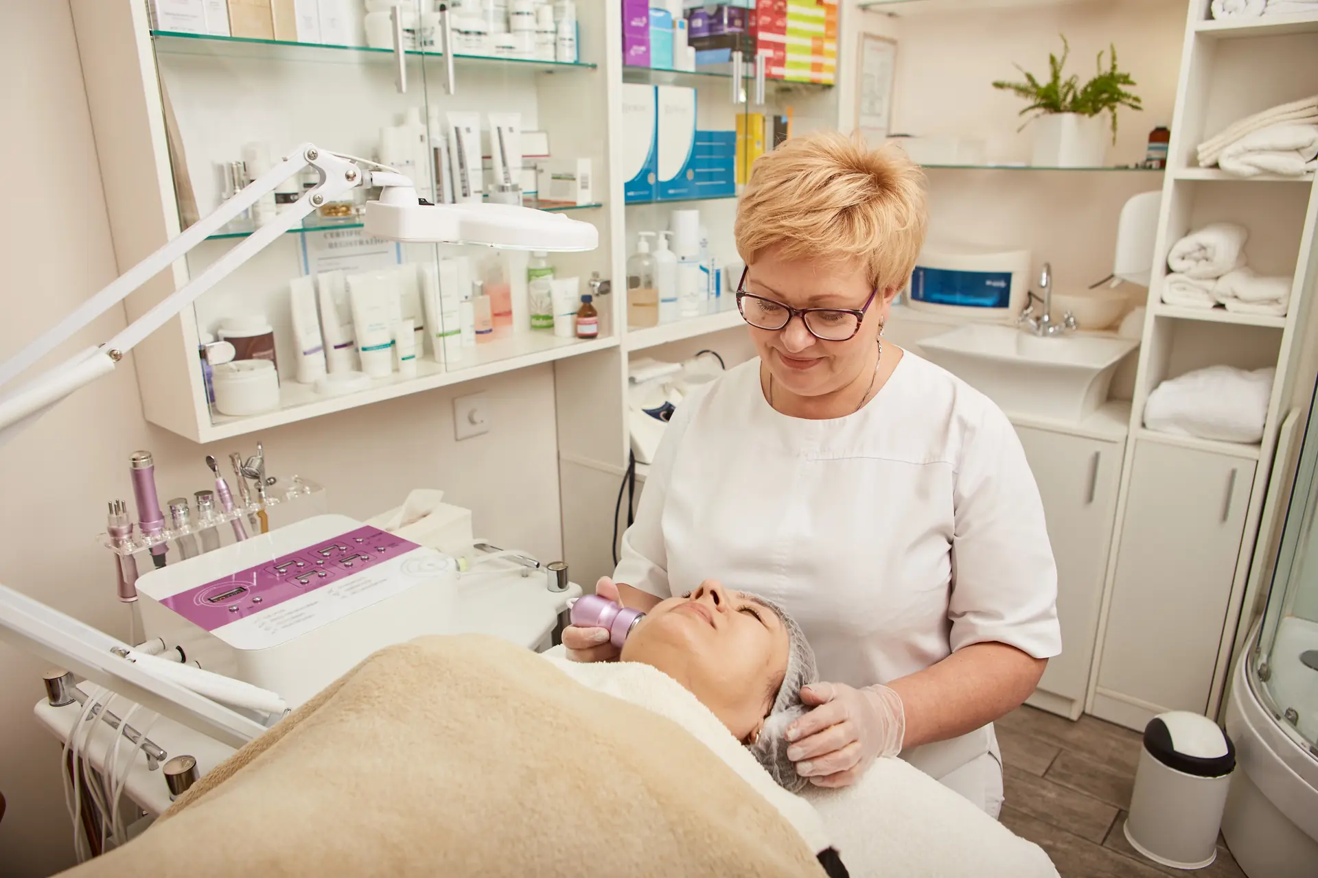 A beautician using a facial cryotherapy massager