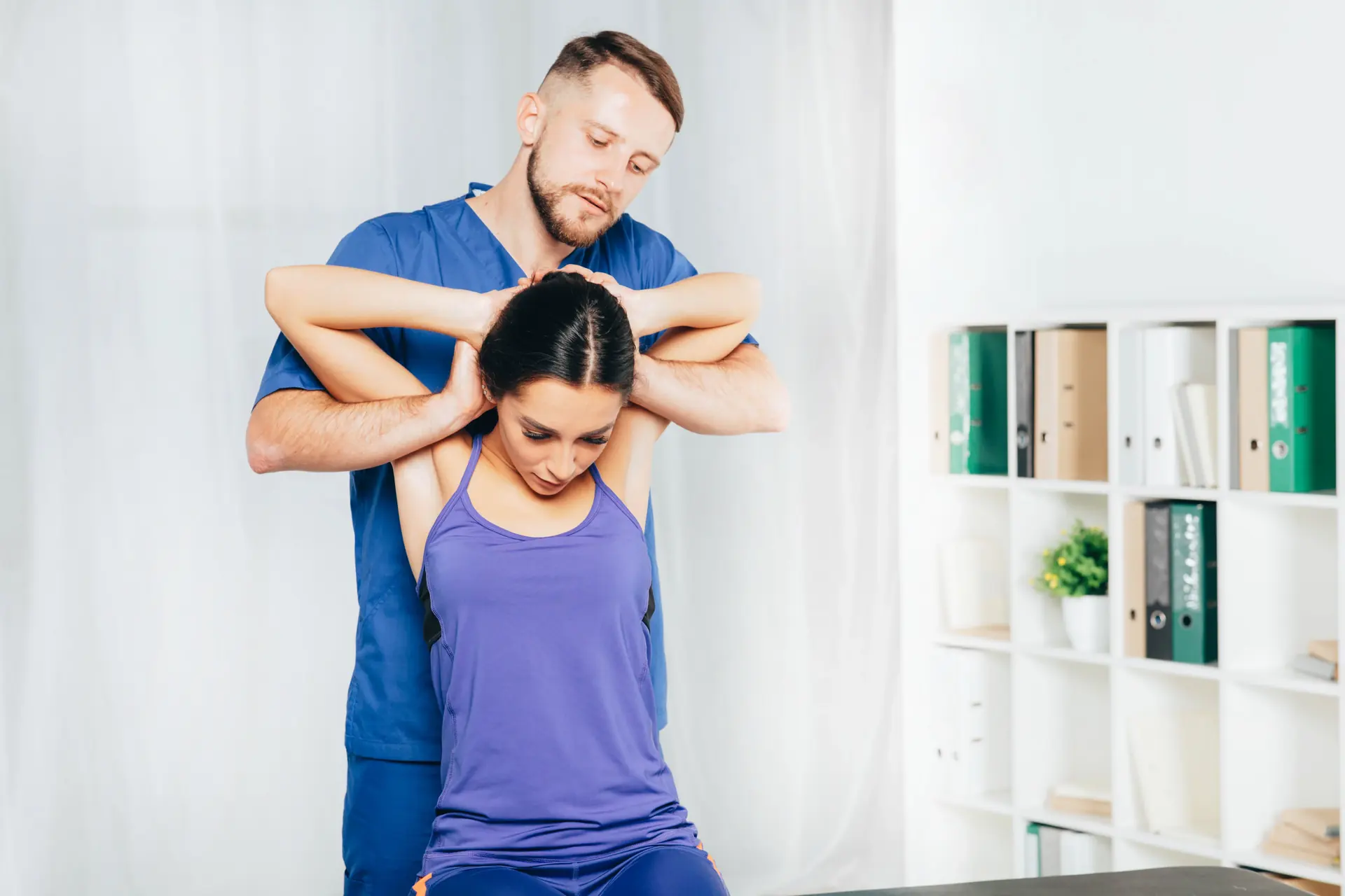 A chiropractor guiding a patient through a rehab exercise
