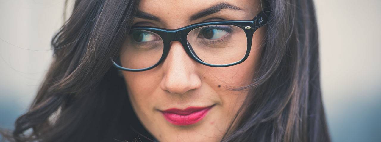 Close-up of a woman wearing dark-rimmed eyeglasses