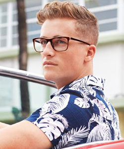 Man in a patterned shirt wearing eyeglasses outdoors