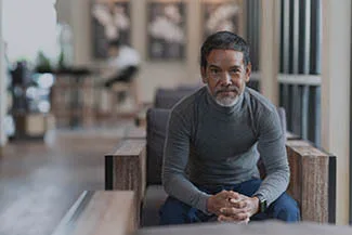 Man sitting indoors wearing bifocal or multifocal lenses