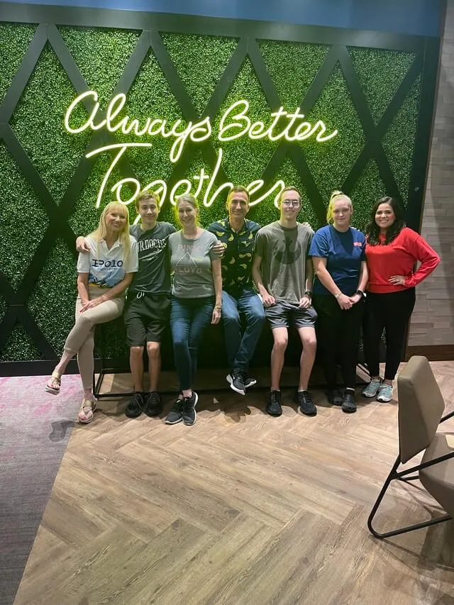 The Vision Pro team under a neon sign reading Always Better Together