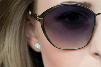 Close-up of woman in large fashion sunglasses with earrings