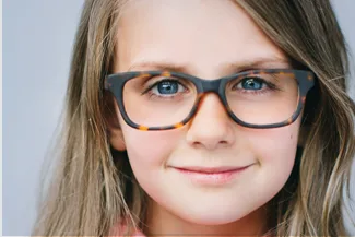 Smiling girl with long hair wearing stylish tortoiseshell glasses
