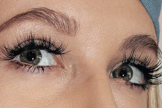 Close-up of woman’s eyes with long lashes enhanced by serum