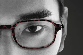 Close-up of man’s eye wearing dark rectangular eyeglasses