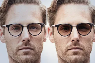 Man wearing two different pairs of eyeglasses for comparison