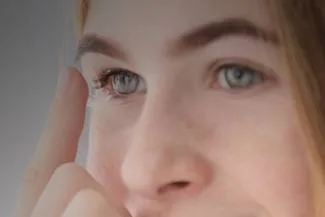 Close-up of woman’s green eye showing scleral contact lens