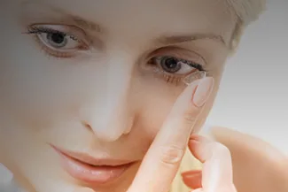 Woman inserting disposable contact lens into her eye